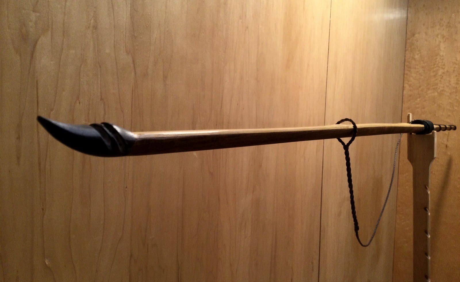 The 45-pound bamboo-backed ipe longbow, unstrung on Doug's tiller: its upper limb and black buffalo horn tip