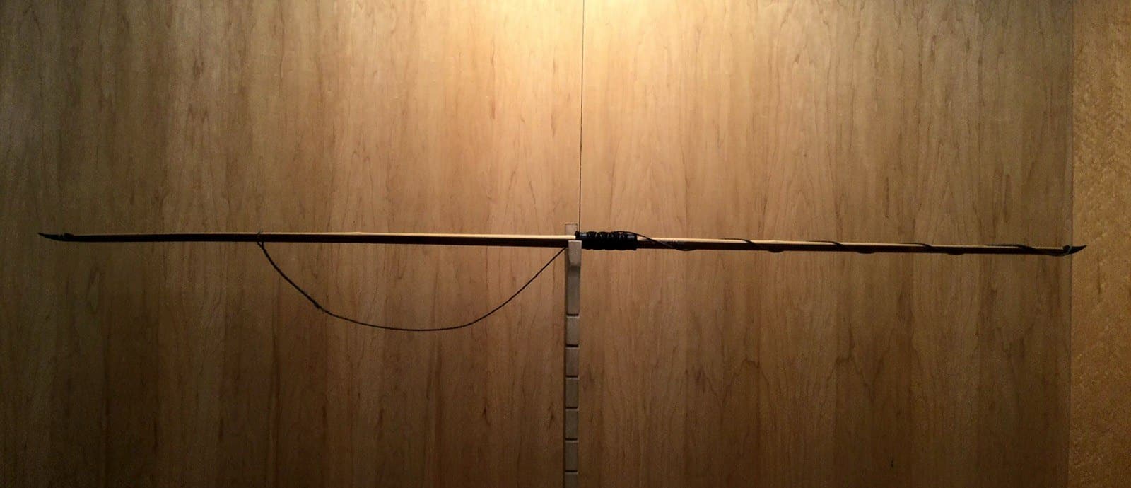 The 65-pound bamboo-backed ipe longbow, unstrung on Doug's tiller with its string hanging