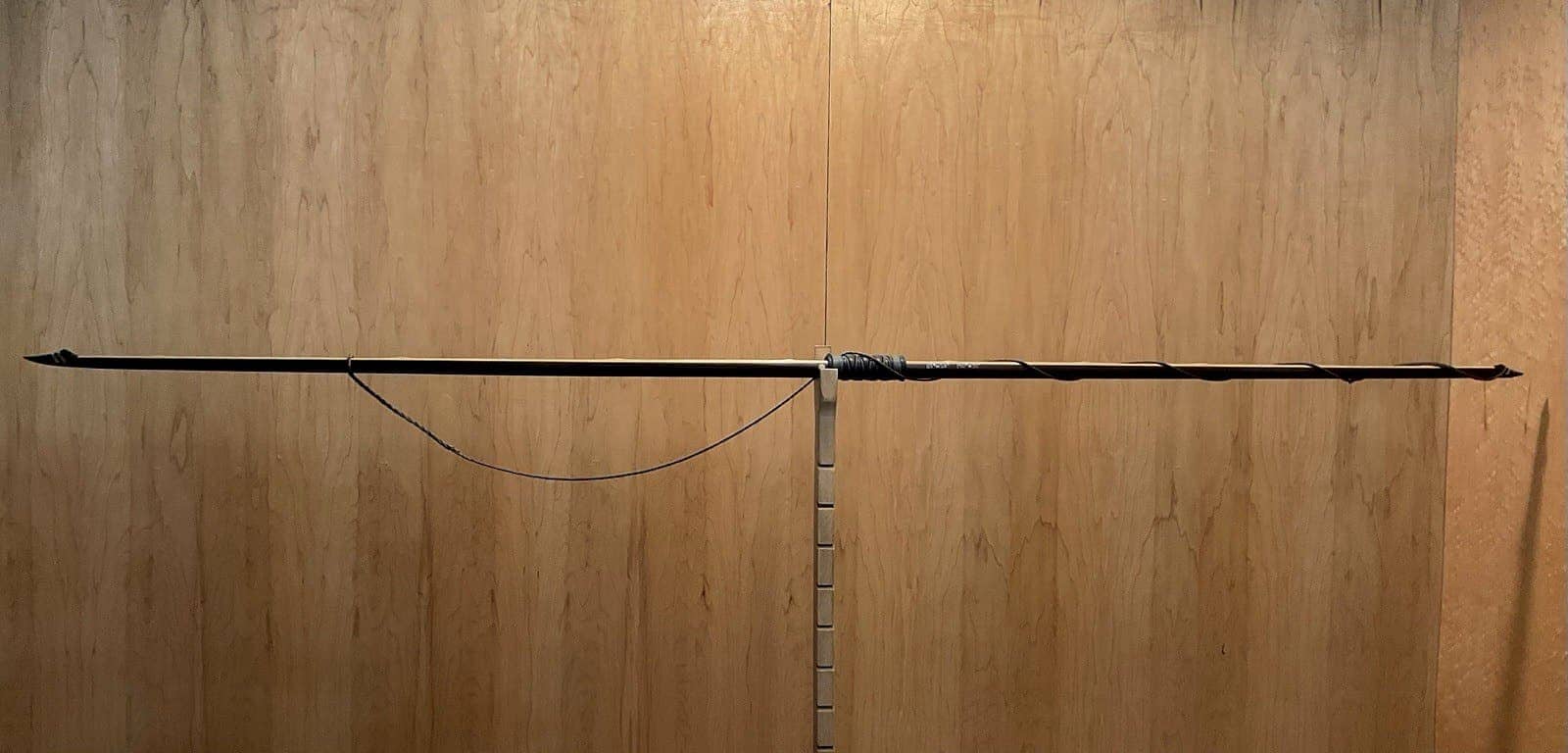 The 115-pound bamboo-backed ipe warbow, unstrung on the tiller, the string hanging slack