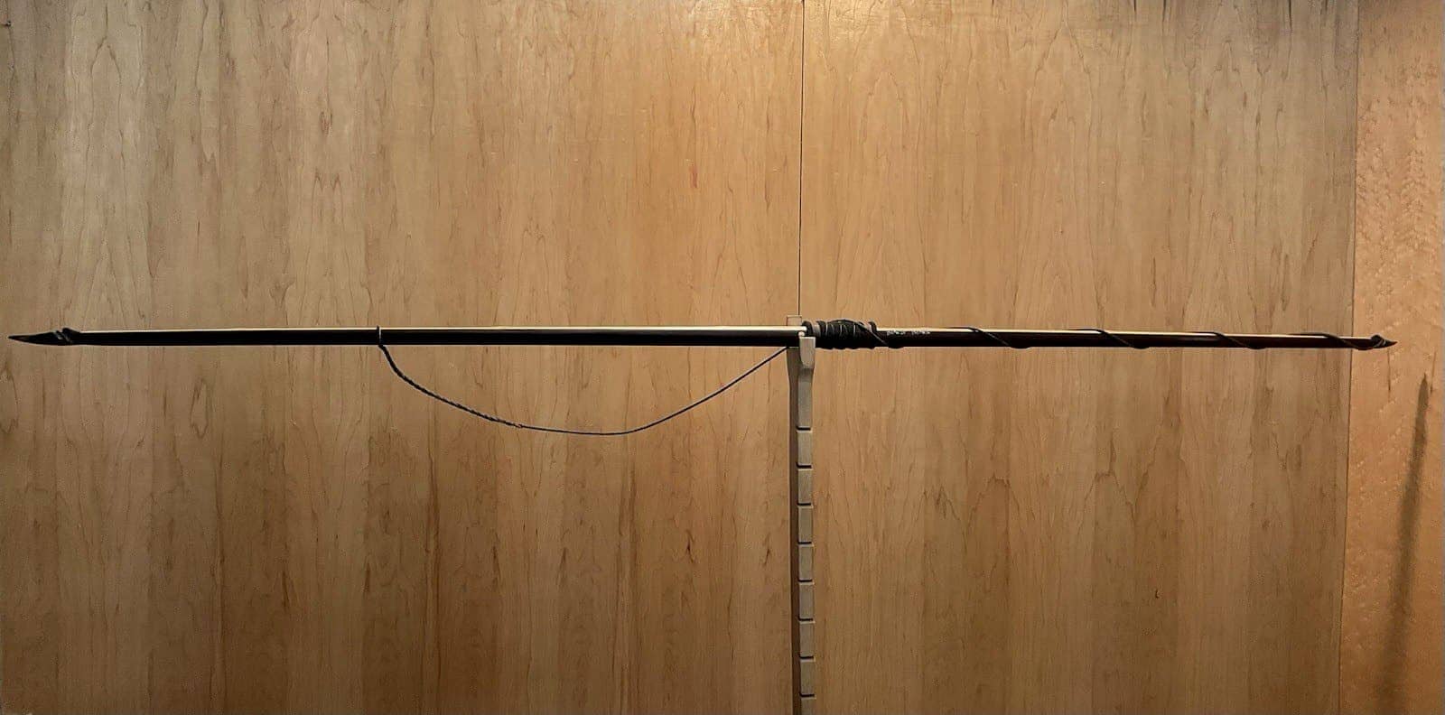 The 150-pound bamboo-backed ipe warbow, unstrung on Doug's tiller, the string hanging slack