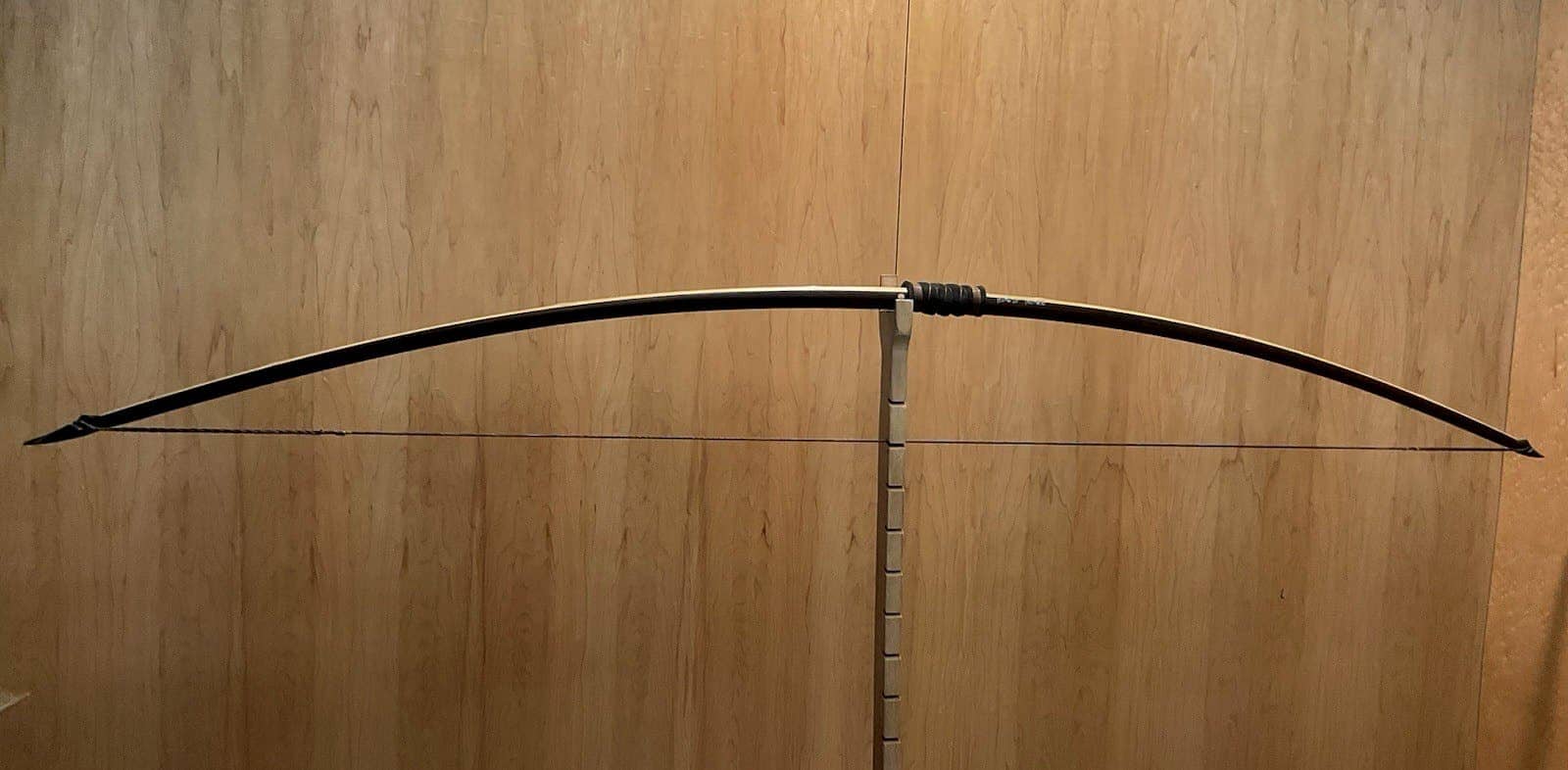The 150-pound bamboo-backed ipe warbow, braced on Doug's tiller against the maple wall