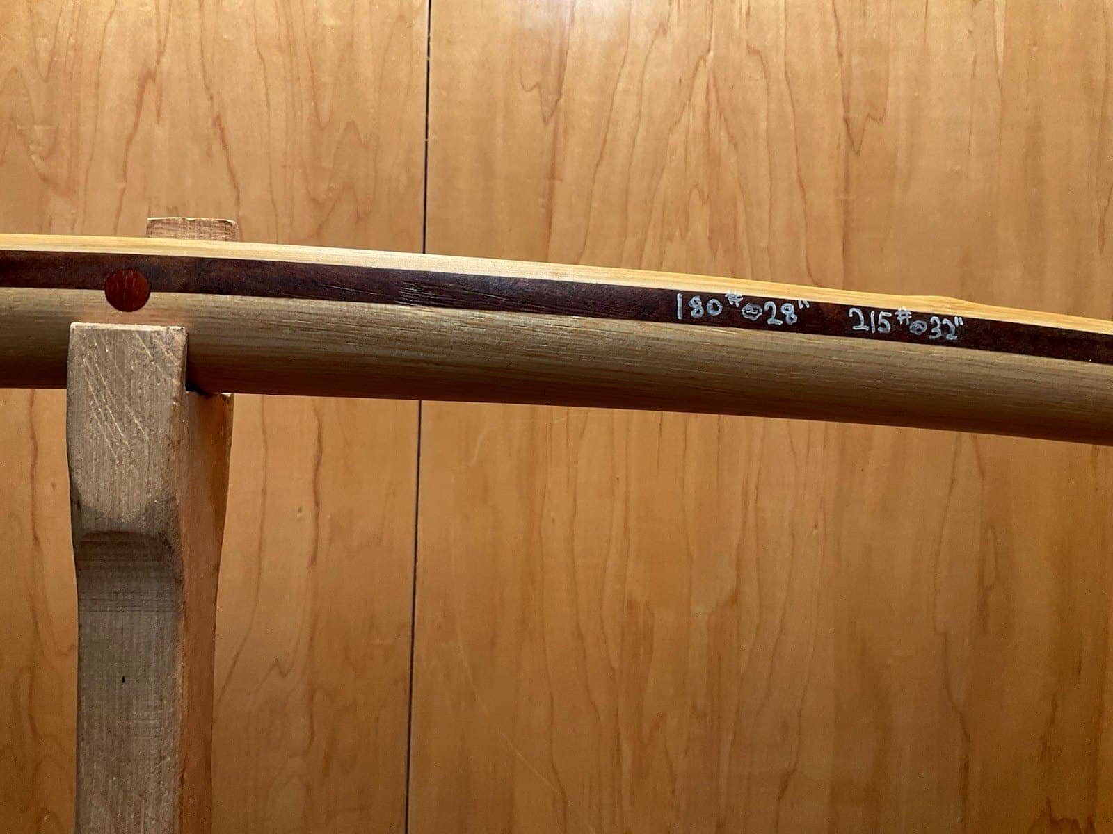 The handle of the 180-pound bamboo-backed tri-lam warbow, its draw weights pencilled on the limb and its three layers in view