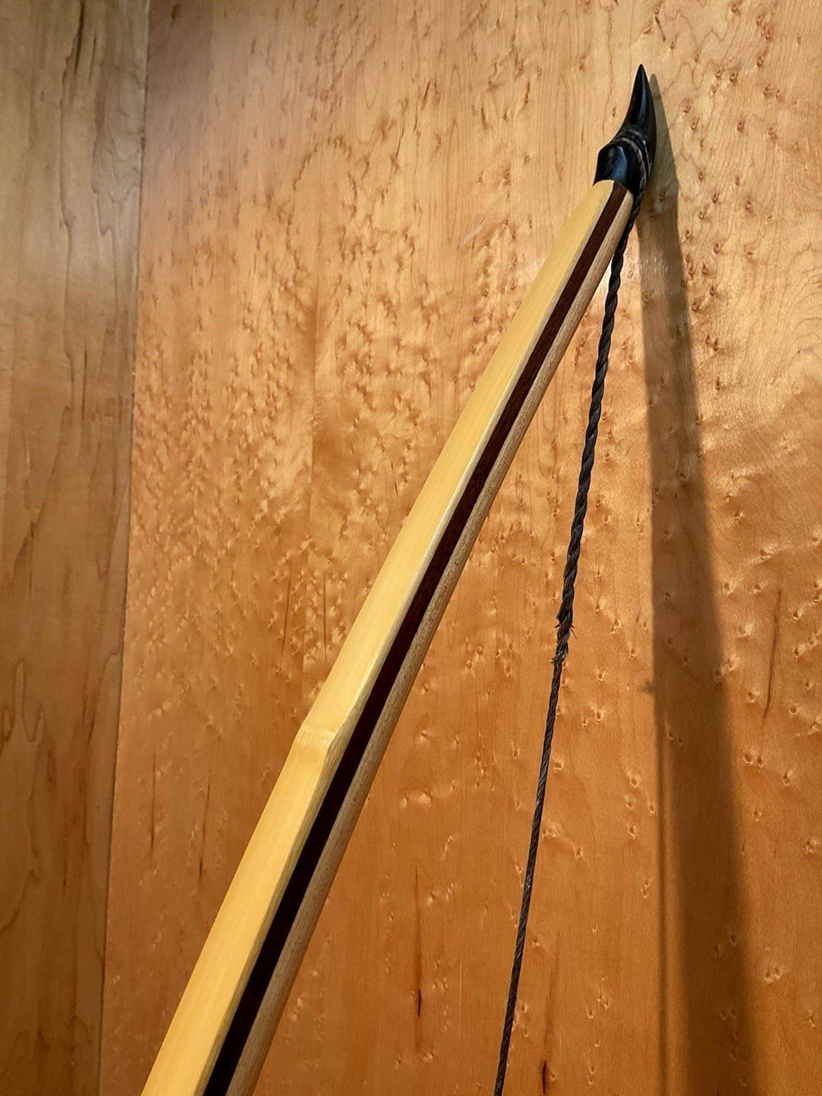 The upper limb and horn of the 180-pound bamboo-backed tri-lam warbow, standing against the maple wall
