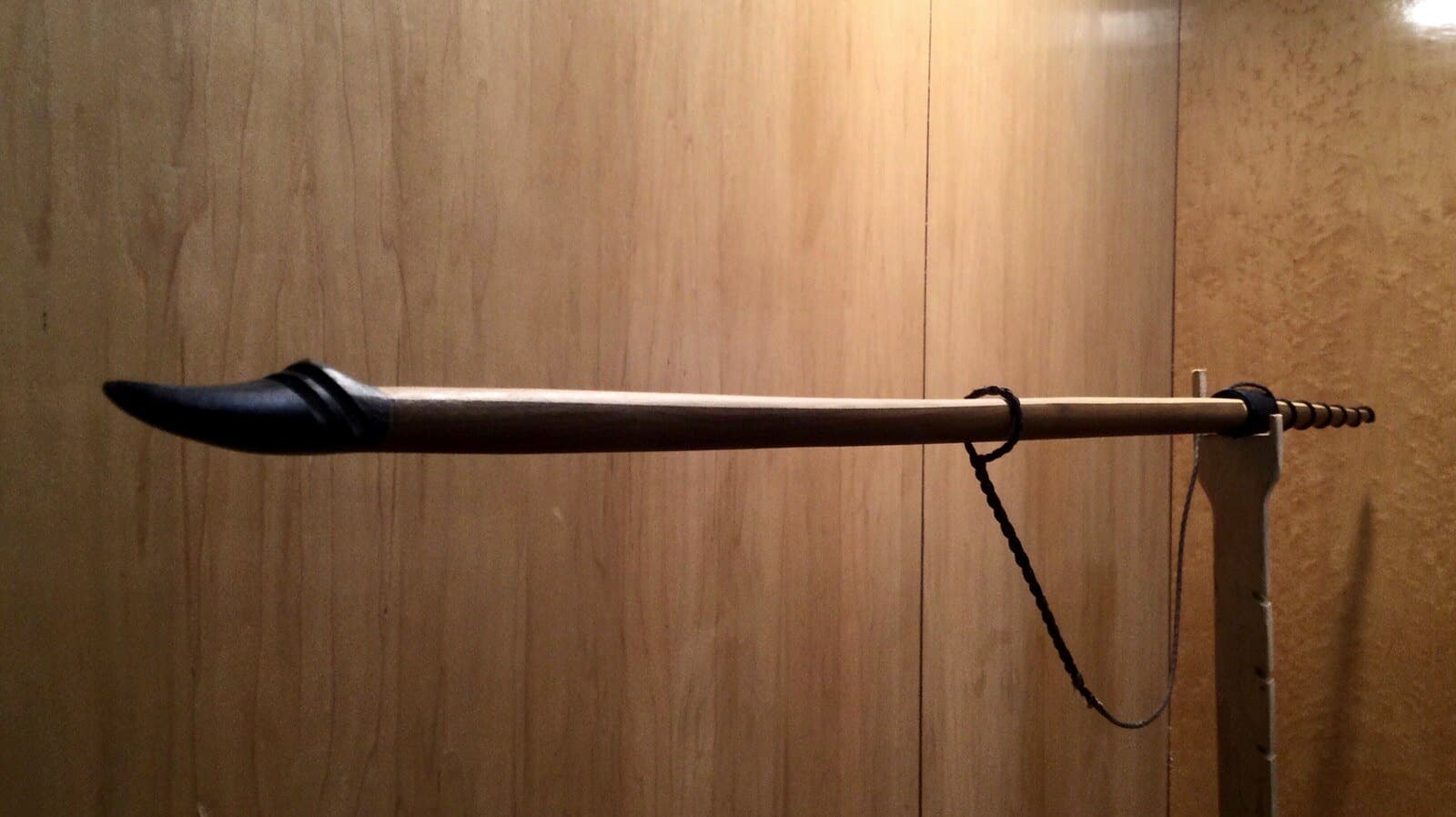 The 40-pound hickory-backed ipe longbow, unstrung on Doug's tiller: its upper limb and black buffalo horn tip