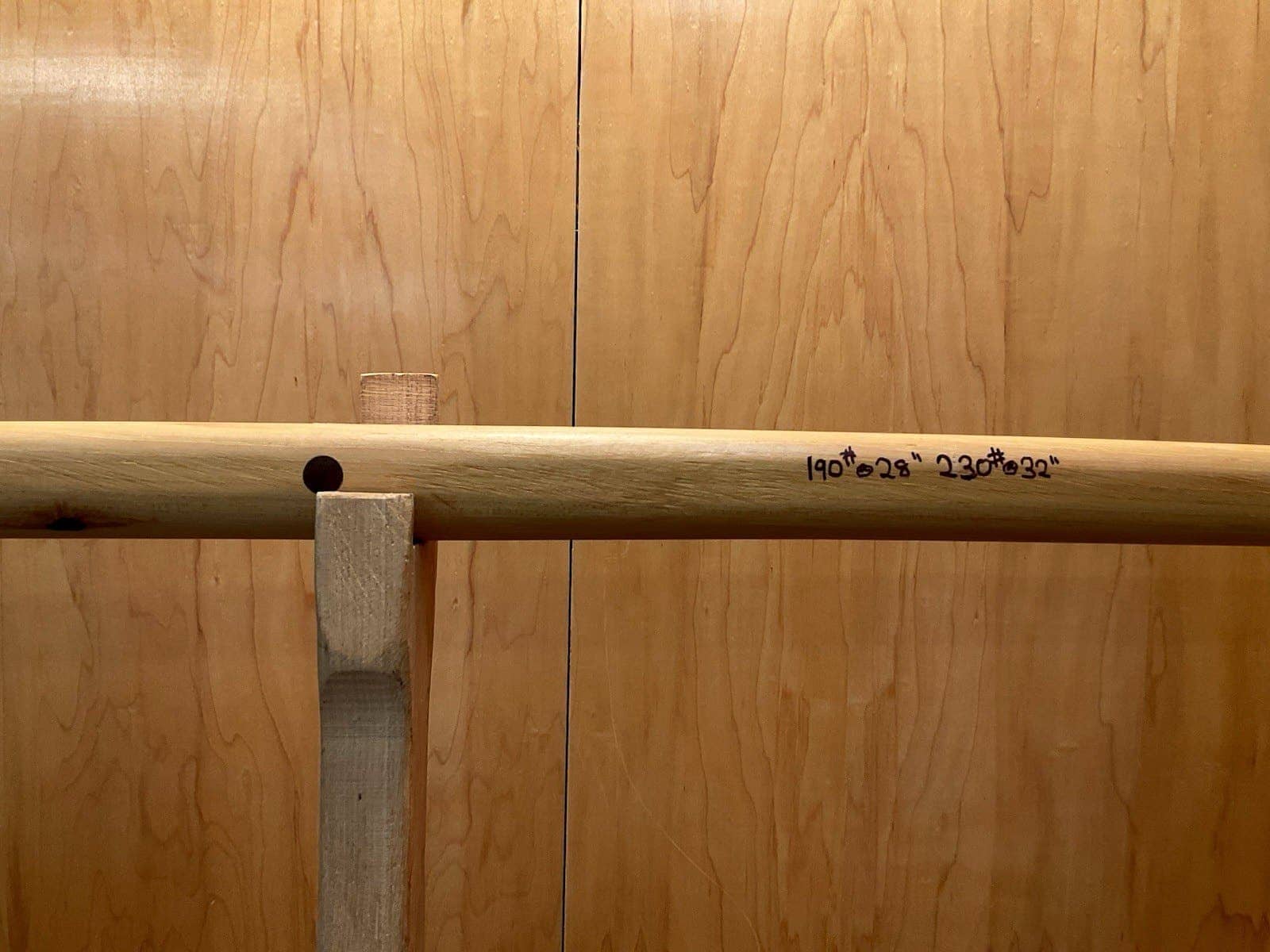 The handle of the 190-pound white hickory selfbow warbow on the tiller, its draw weights pencilled on the limb