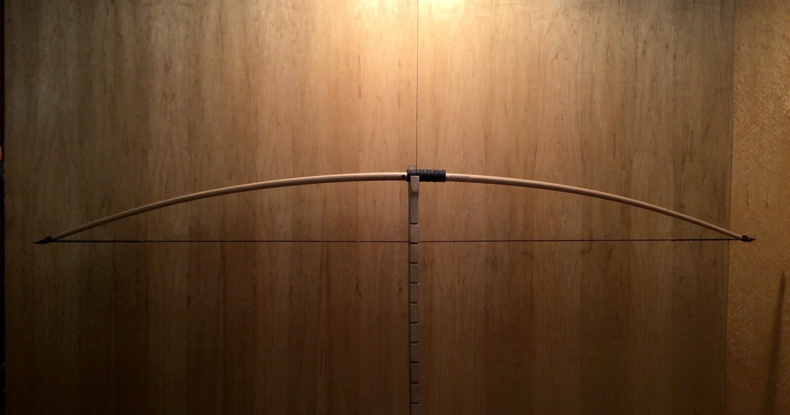 The 60-pound white hickory selfbow warbow, braced on Doug's tiller against the maple wall